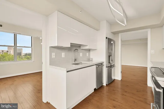 a kitchen with stainless steel appliances granite countertop a sink refrigerator and cabinets