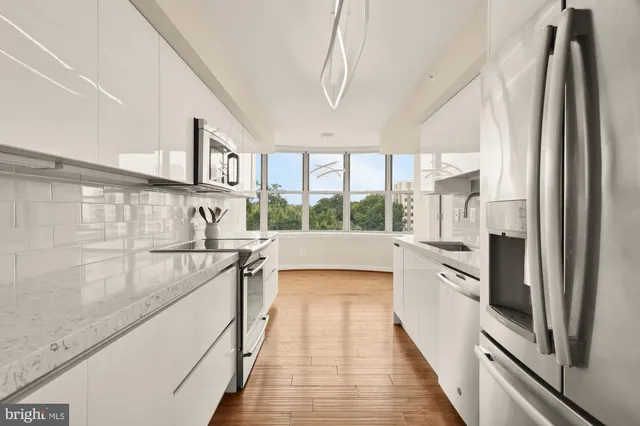 a kitchen with stainless steel appliances a sink stove and cabinets