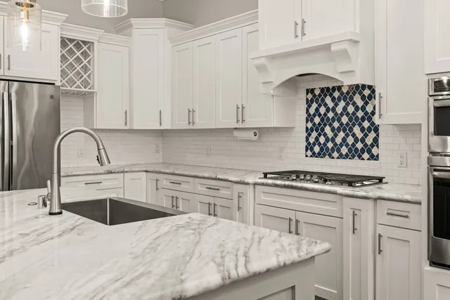 a kitchen with white cabinets and appliances