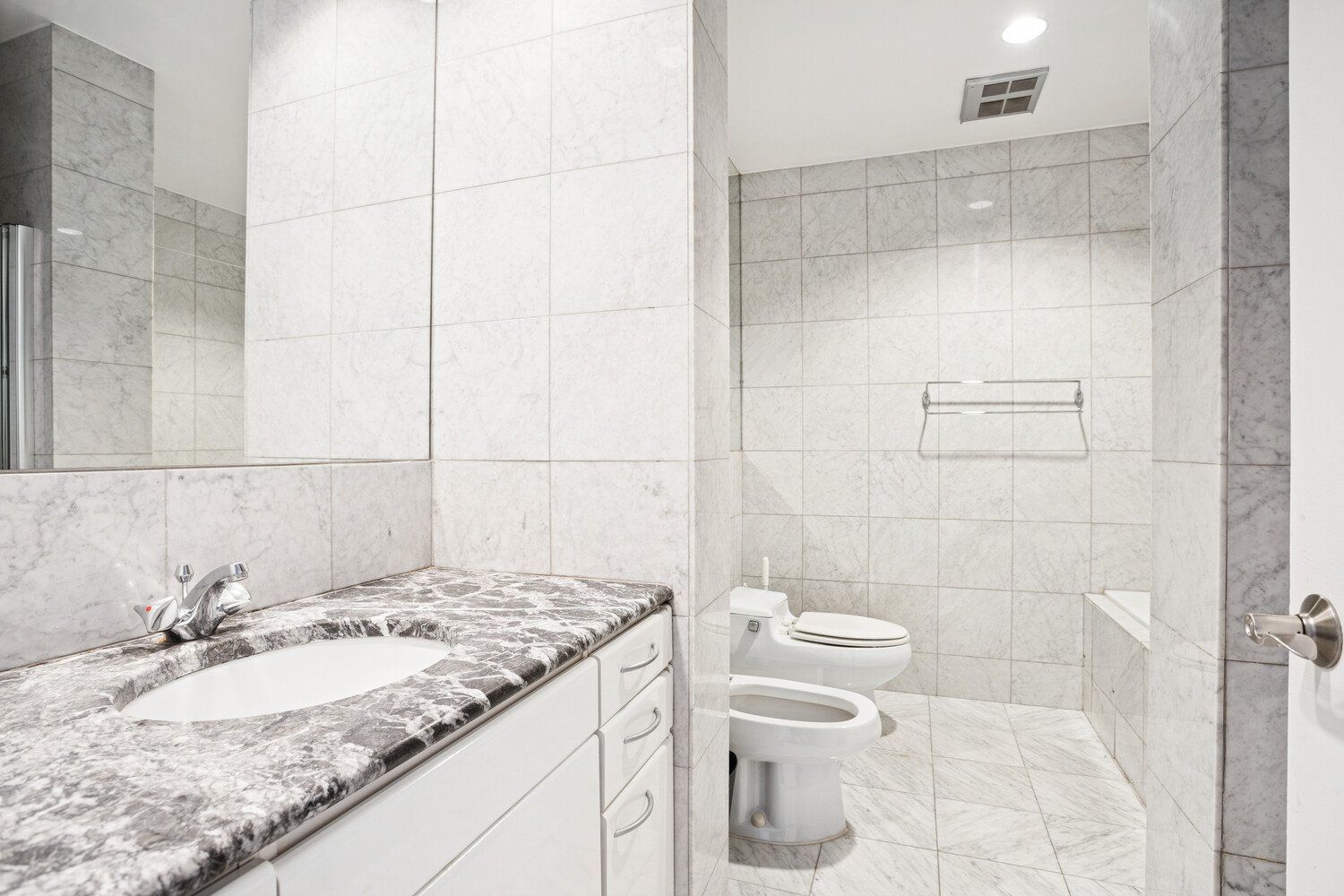 146 West 57th Street, Unit 34A Manhattan, NY 10019 - Photo 7 of 15 a bathroom with a granite countertop sink toilet and shower