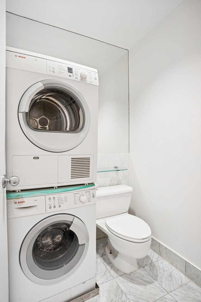 146 West 57th Street, Unit 34A Manhattan, NY 10019 - Photo 8 of 15 a utility room with dryer and washer