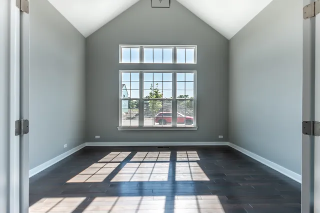 an empty room with wooden floor and a window