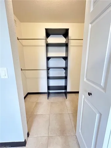 a view of walk in closet with empty racks