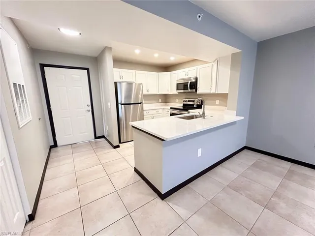 a kitchen with a sink a stove a refrigerator a microwave oven and a window