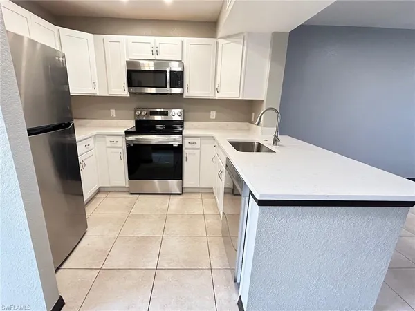 a kitchen with a sink a stove top oven and refrigerator