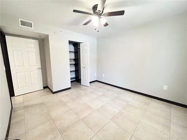 an empty room with closet and fan