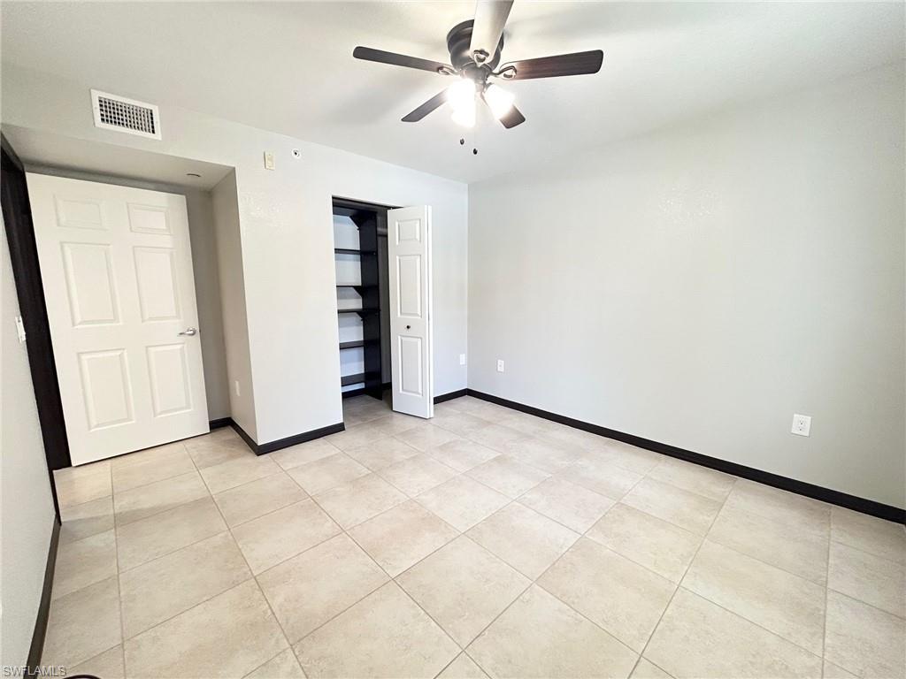 8284 Key Royal Circle, Unit 1323 Naples, FL 34119 - Photo 8 of 16 an empty room with closet and fan