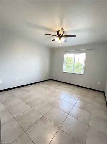 an empty room with windows and ceiling fan