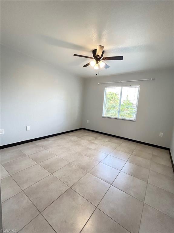 8284 Key Royal Circle, Unit 1323 Naples, FL 34119 - Photo 9 of 16 an empty room with windows and ceiling fan