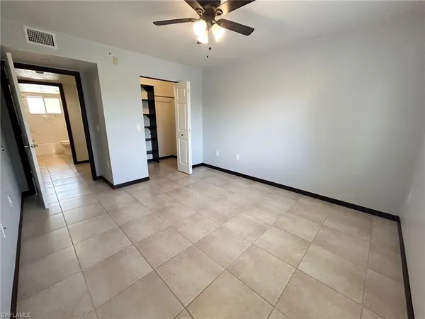 an empty room with a fireplace and a chandelier fan