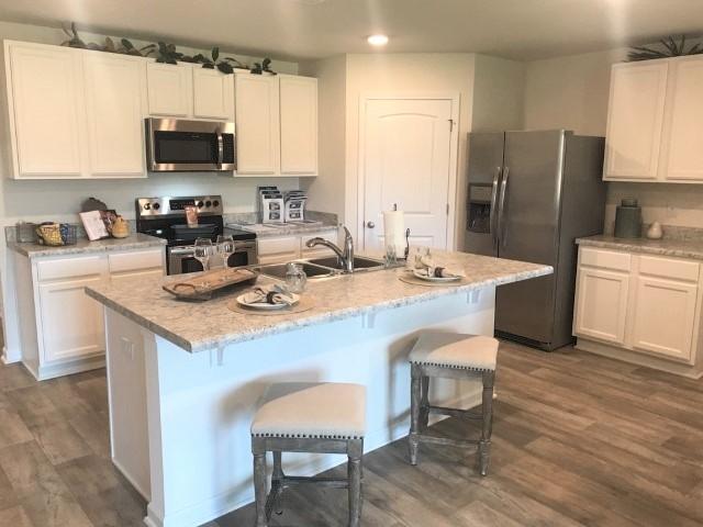 3476 Sparco Drive Crestview, FL 32539 - Photo 4 of 18 a kitchen with stainless steel appliances a stove a sink a microwave a refrigerator and cabinets