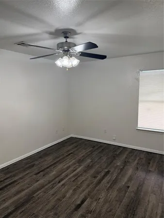 a view of a room that has a fan and wooden floor
