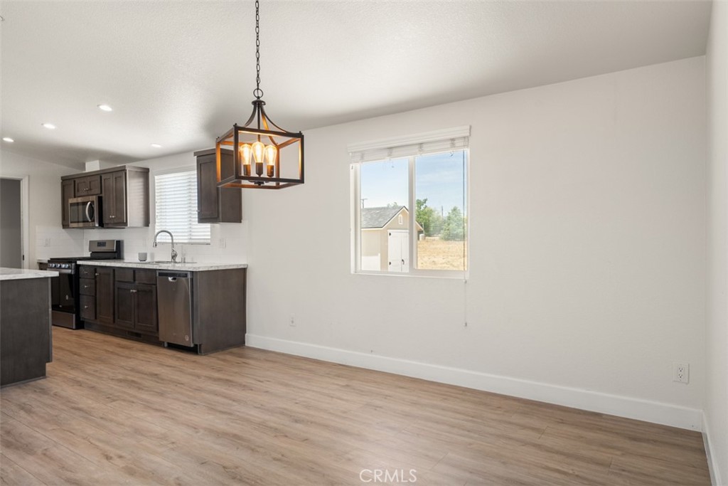 56040 Pena Road Anza, CA 92539 - Photo 14 of 42 a kitchen with stainless steel appliances granite countertop a sink cabinets and wooden floor