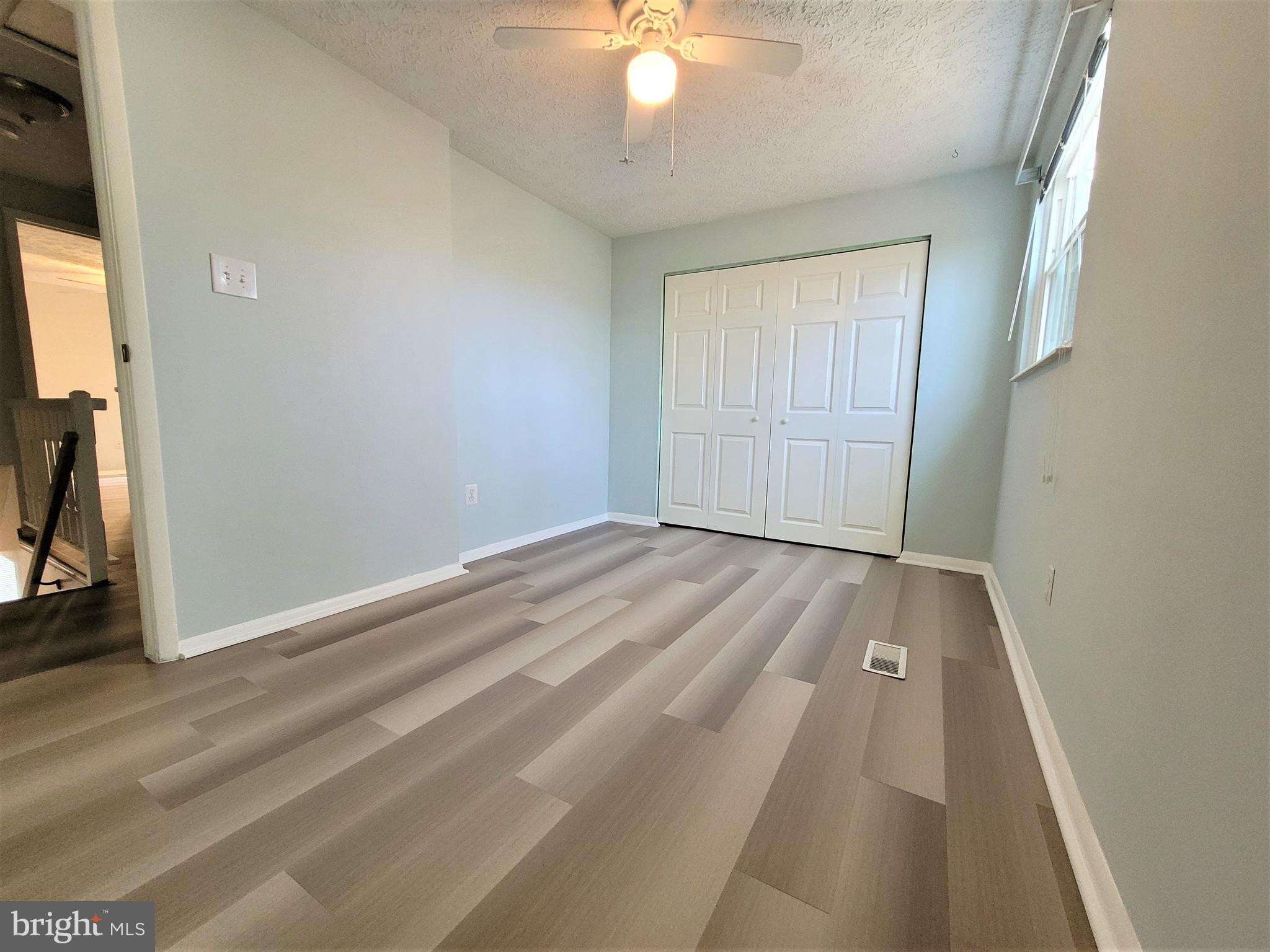 8072 Grandview Court Springfield, VA 22153 - Photo 20 of 32 an empty room with wooden floor fan and windows