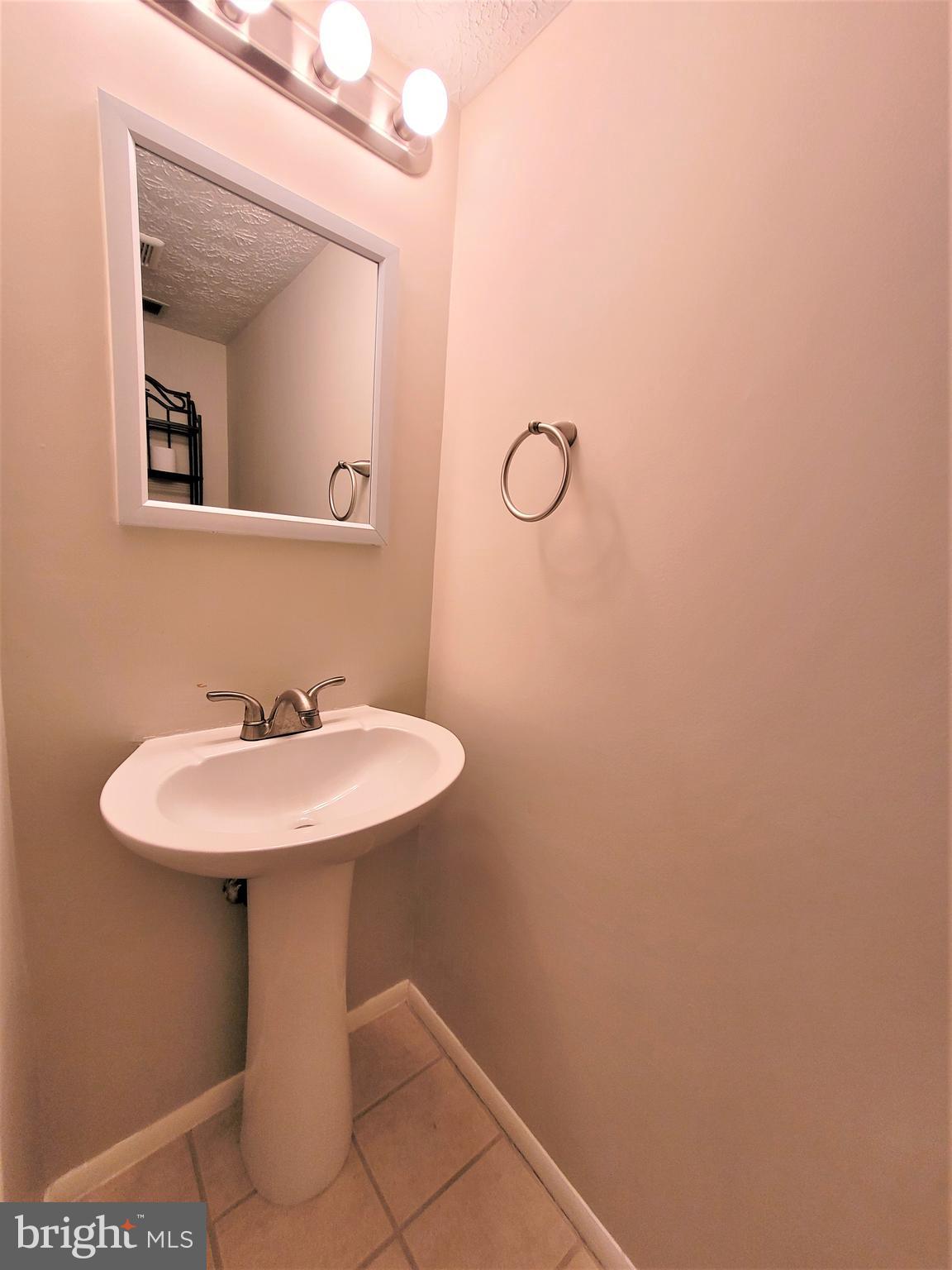 8072 Grandview Court Springfield, VA 22153 - Photo 25 of 32 a bathroom with a sink a mirror and vanity