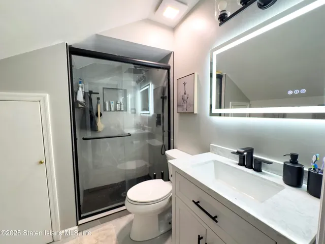 a bathroom with a toilet a sink and mirror