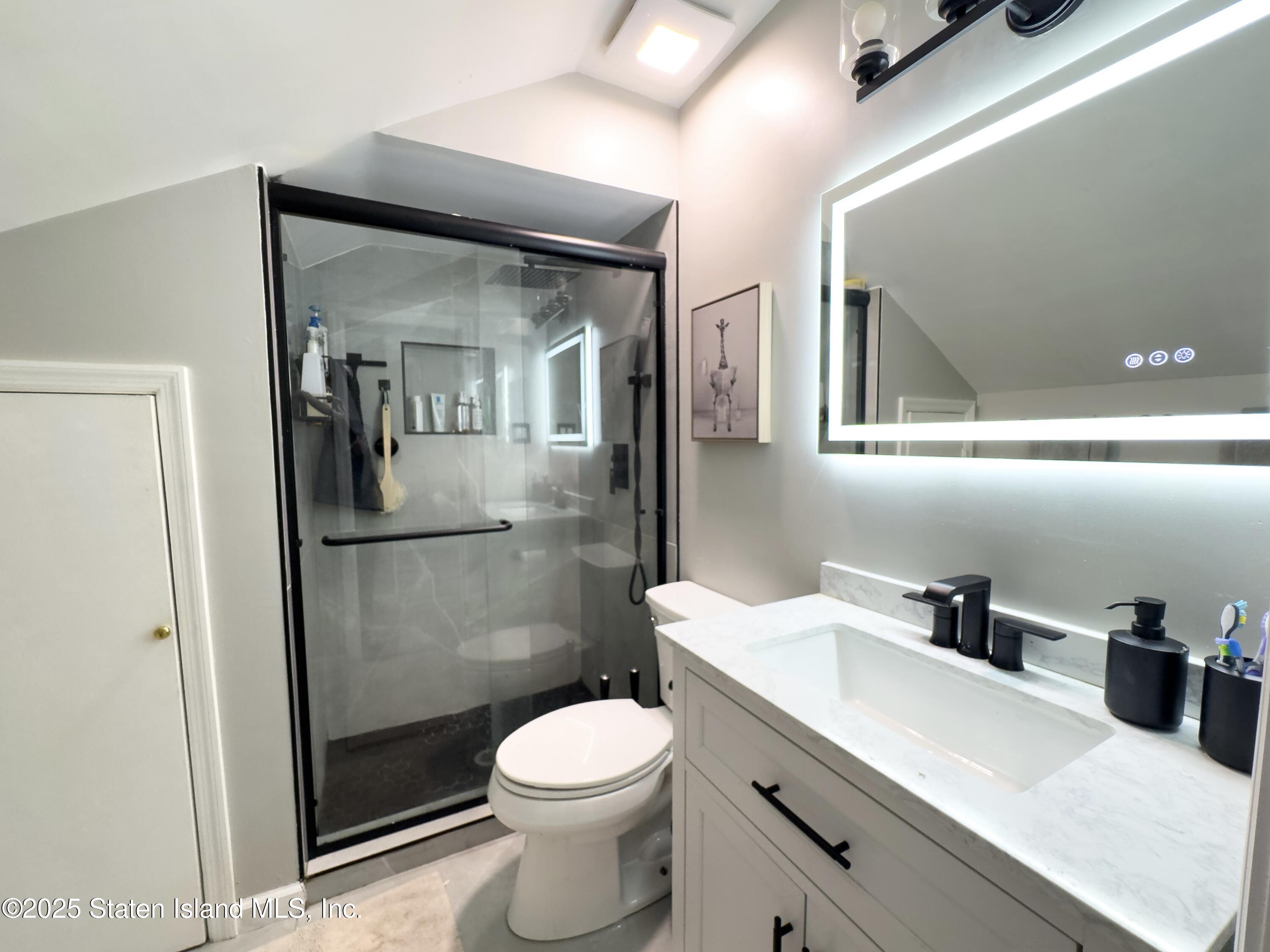 280 Rolling Hill Green Staten Island, NY 10312 - Photo 12 of 22 a bathroom with a toilet a sink and mirror