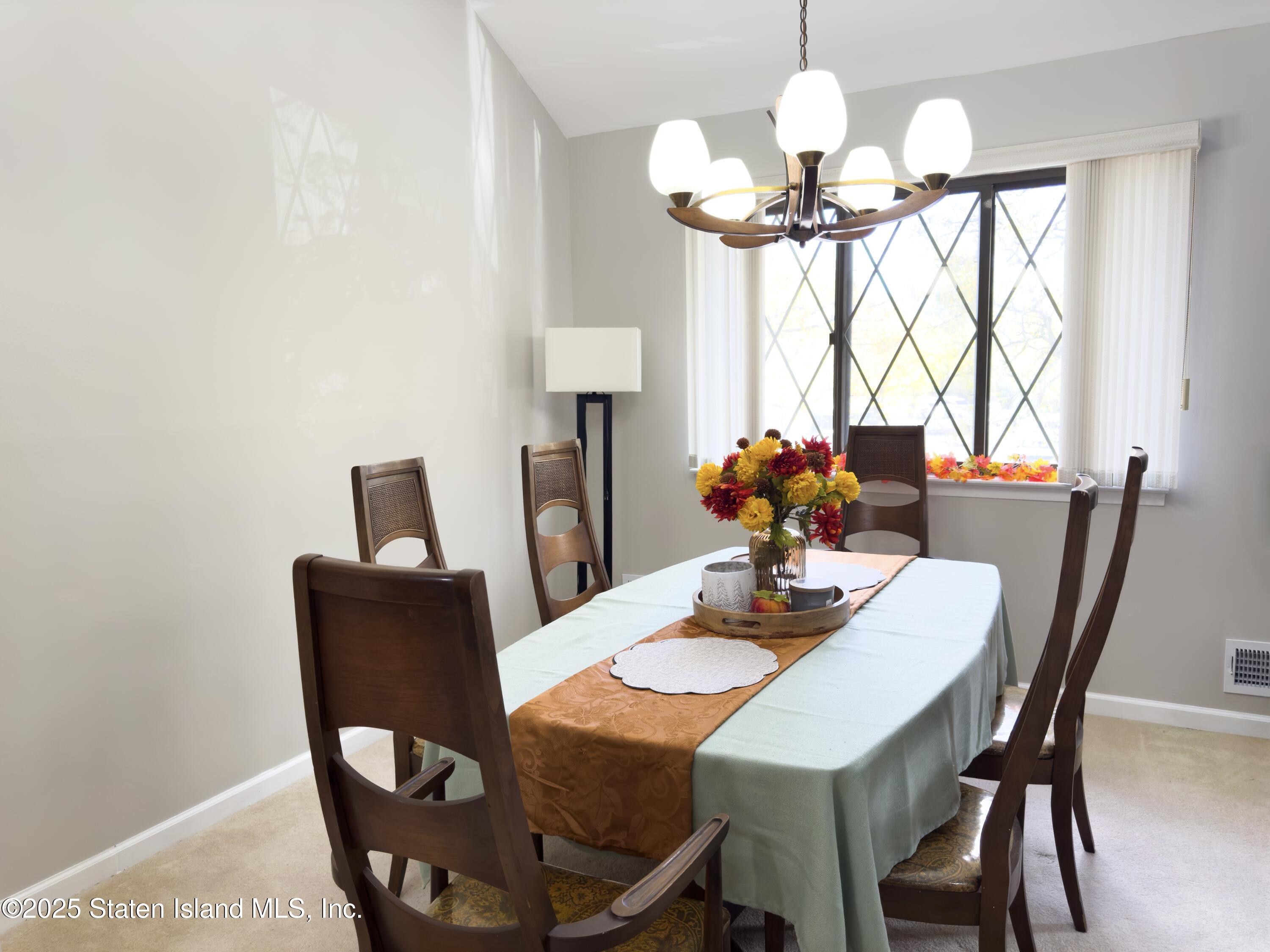 280 Rolling Hill Green Staten Island, NY 10312 - Photo 9 of 22 a dining room with furniture and chandelier