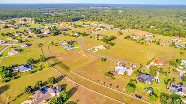 an aerial view of ocean and residential houses with outdoor space