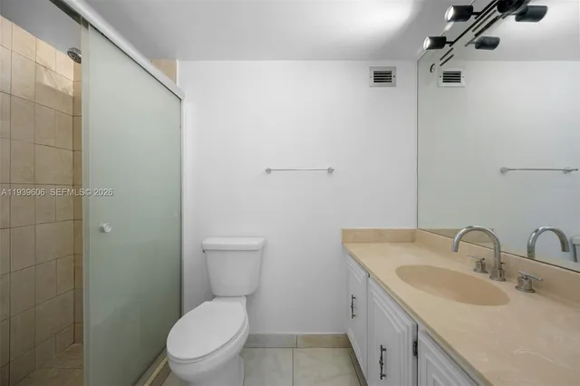 a bathroom with a toilet sink vanity and mirror