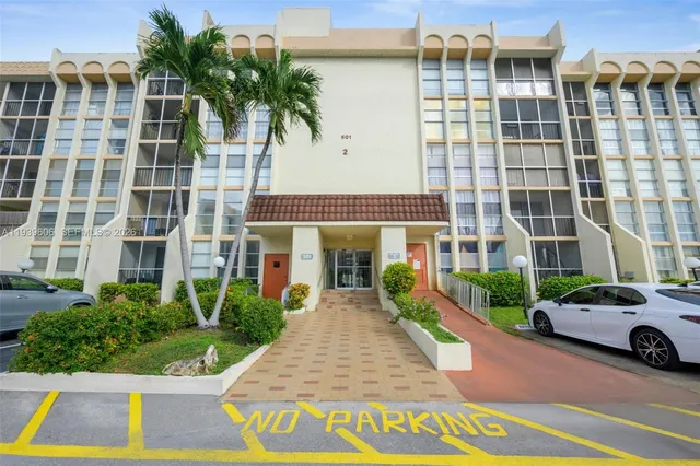 a view of a building with a yard and potted plants