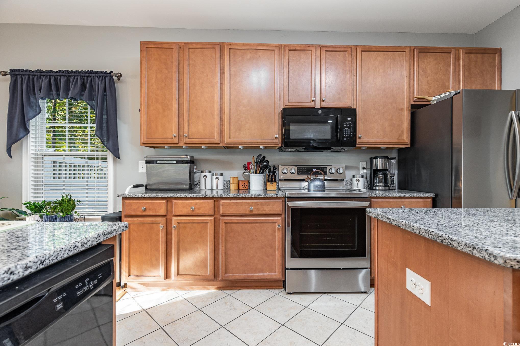 281 Marsh Tacky Loop Myrtle Beach, SC 29588 - Photo 5 of 39 Kitchen with black appliances, light stone counter