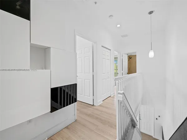 a view of a hallway with wooden floor and staircase