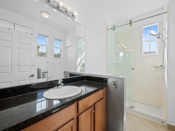 a bathroom with a granite countertop sink and a mirror