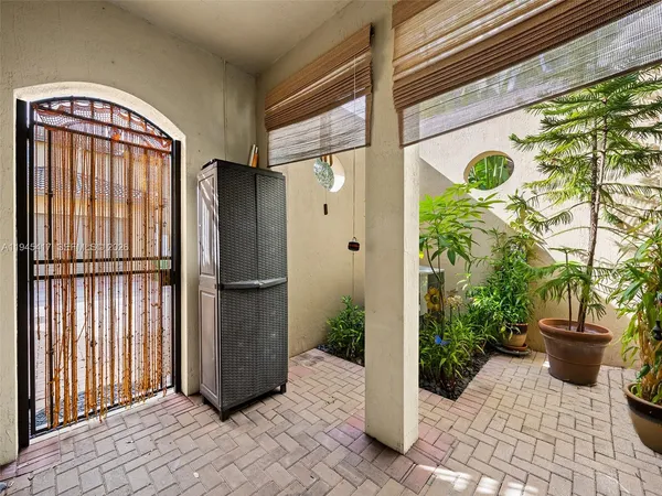 a view of a door and chair and potted plants
