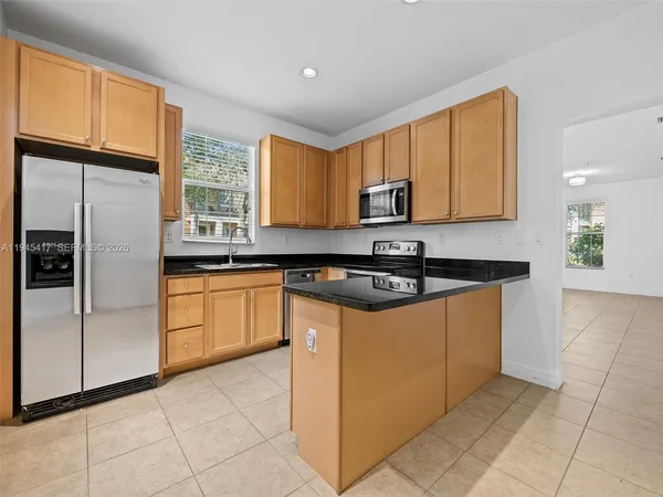 a kitchen with stainless steel appliances granite countertop a stove a sink and a refrigerator