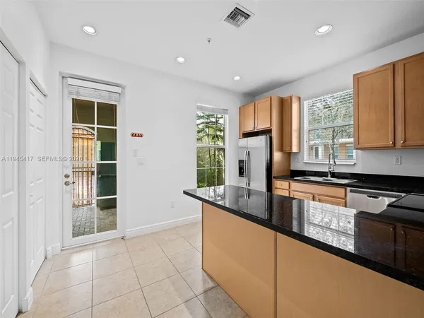 a kitchen with granite countertop a stove sink and cabinets