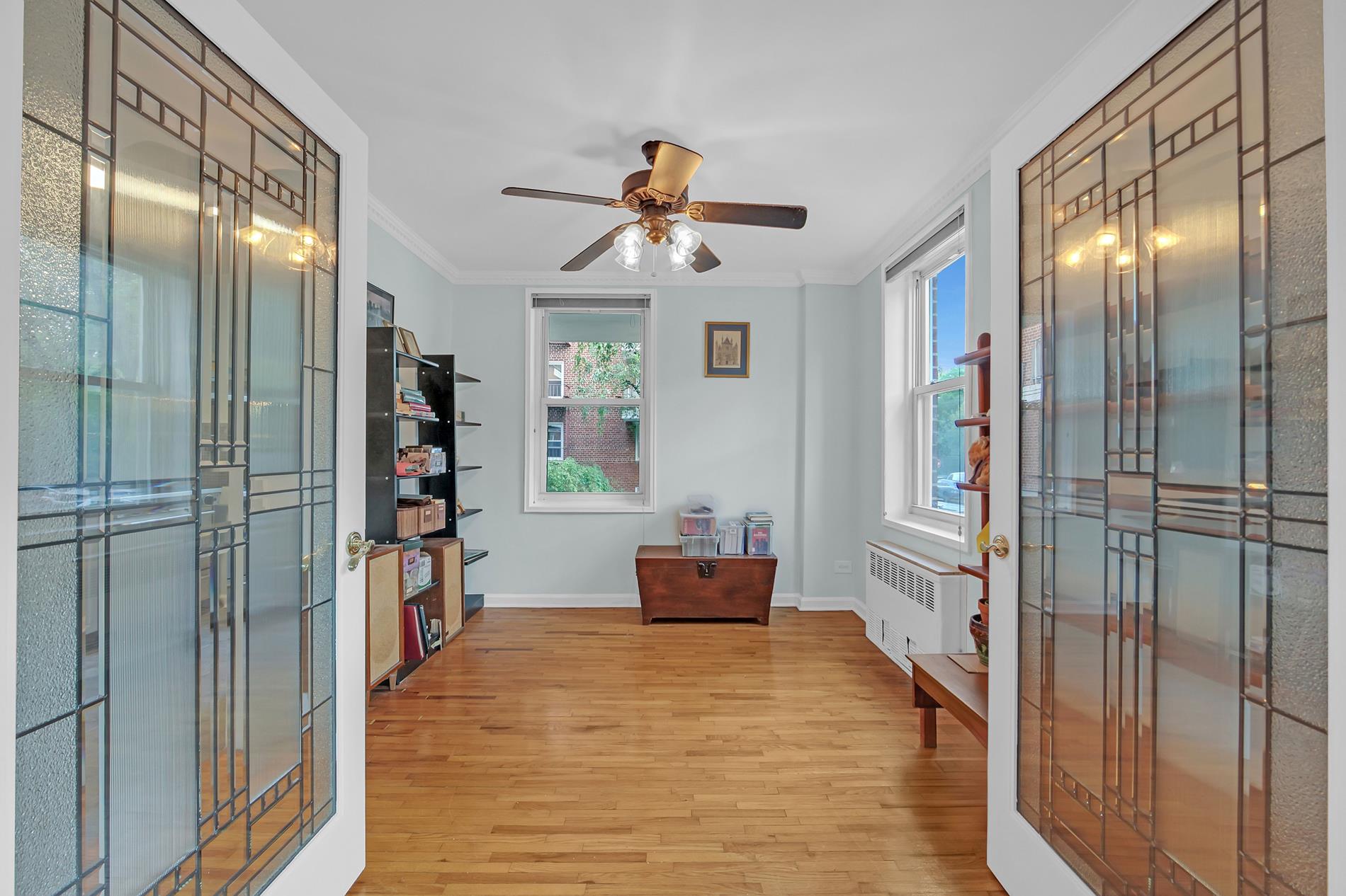 9411 Shore Road, Unit 1O Brooklyn, NY 11209 - Photo 8 of 18 a bedroom with a balcony a bed and a chandelier