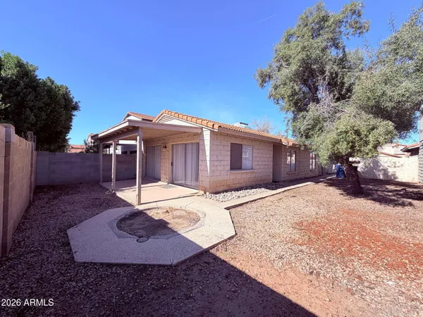 a backyard of a house with wooden fence and large trees