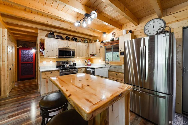 a kitchen with stainless steel appliances granite countertop a refrigerator a sink and a stove