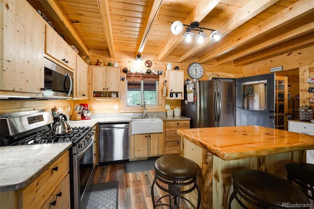 a kitchen with stainless steel appliances a table chairs and a refrigerator