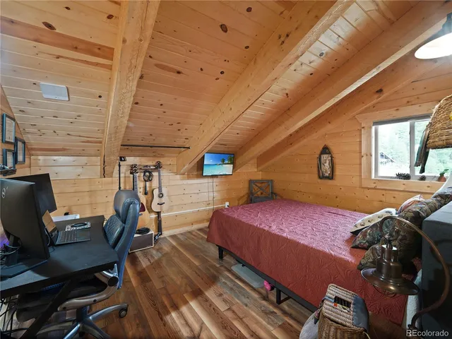 a bedroom with a bed a chair and large window