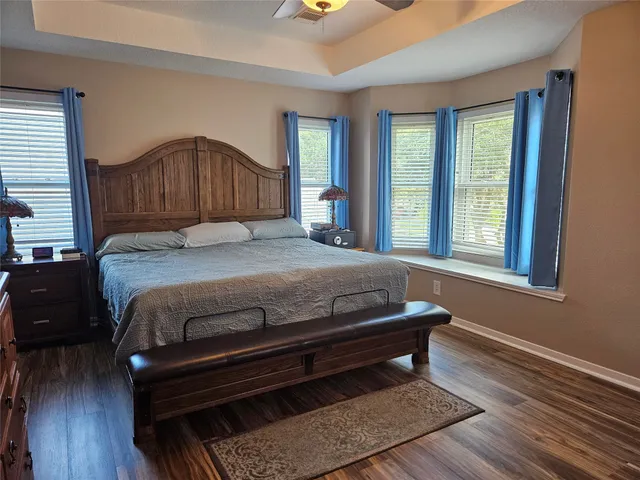 a bedroom with a bed window and wooden floor