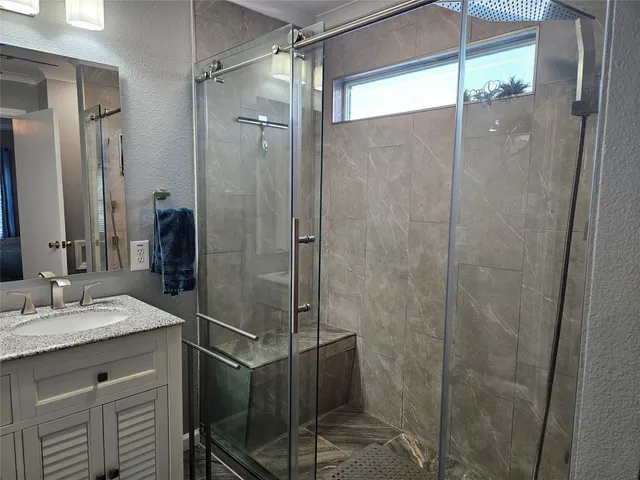 a bathroom with a shower and a sink a mirror