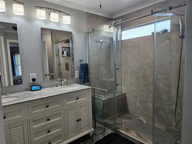 a bathroom with a granite countertop sink mirror and shower