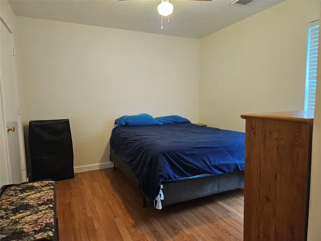 a bedroom with a bed and wooden floor