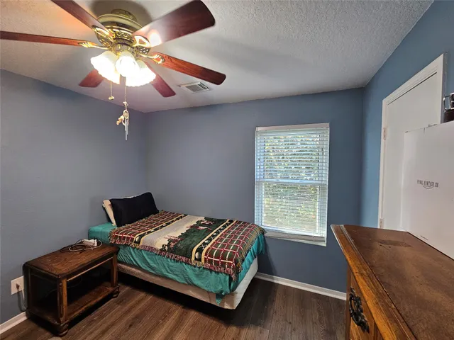 a bedroom with a bed window and wooden floor