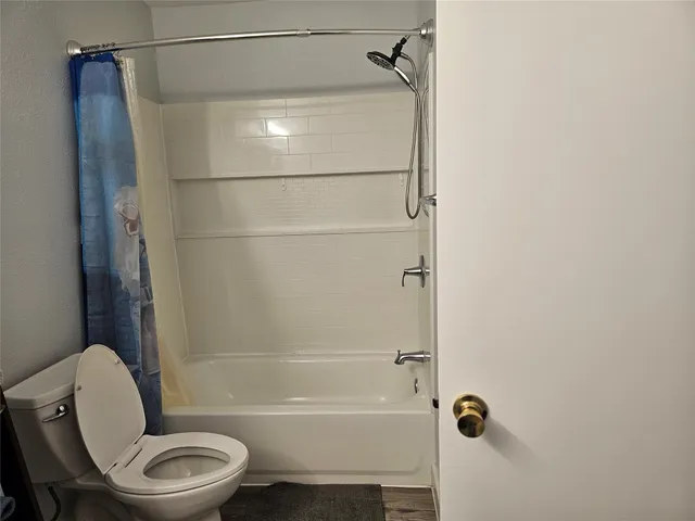 a bathroom with a toilet and a shower