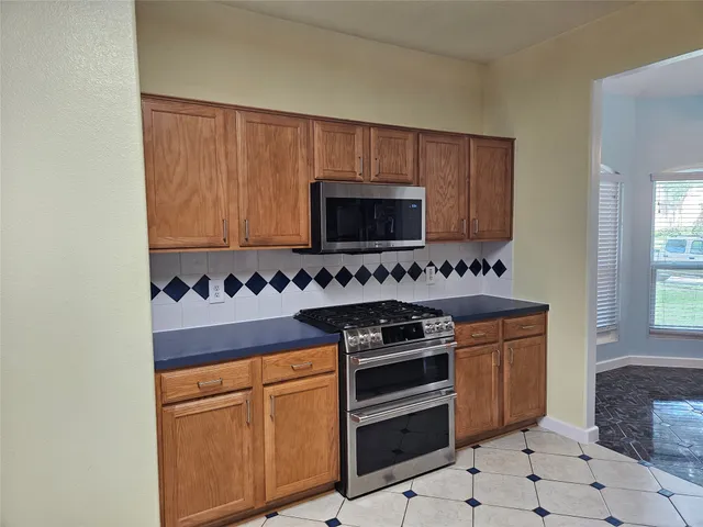 a kitchen with stainless steel appliances granite countertop a sink stove and microwave
