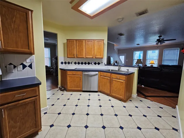 a kitchen with stainless steel appliances a sink a stove a refrigerator and cabinets