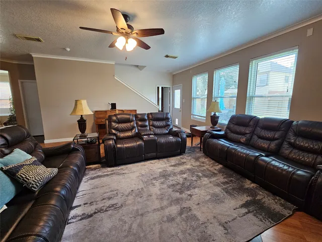 a living room with furniture ceiling fan and a window