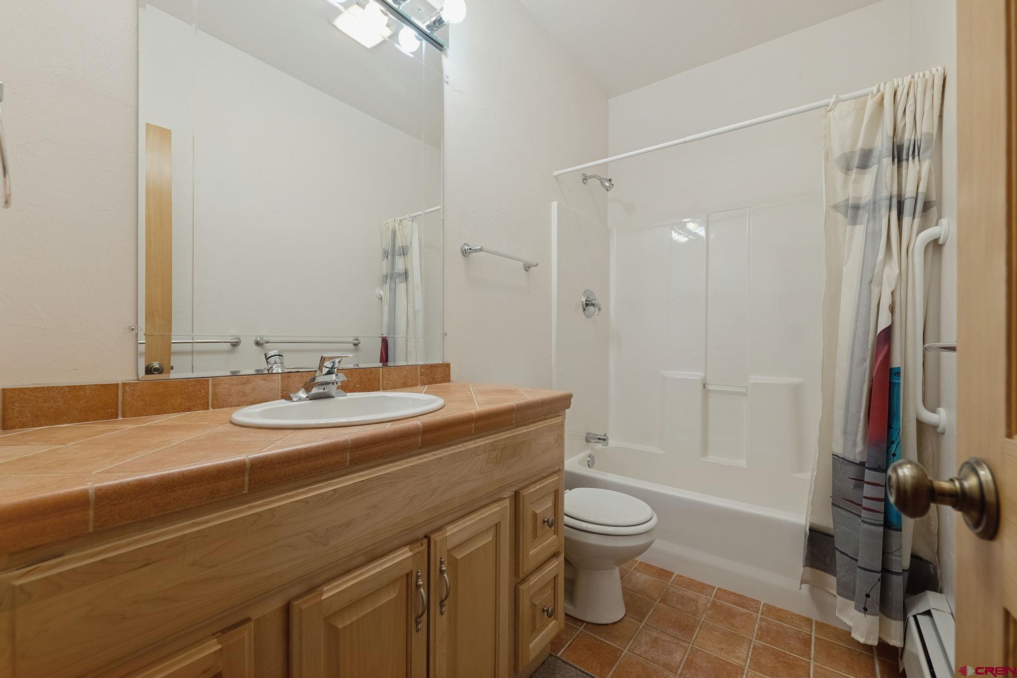 481 Far View Road Durango, CO 81303 - Photo 33 of 45 a bathroom with a granite countertop sink toilet a mirror and shower