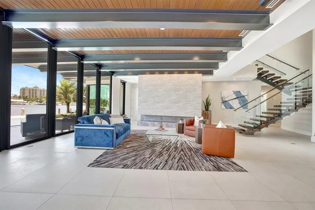 a living room with furniture floor to ceiling window and a flat screen tv