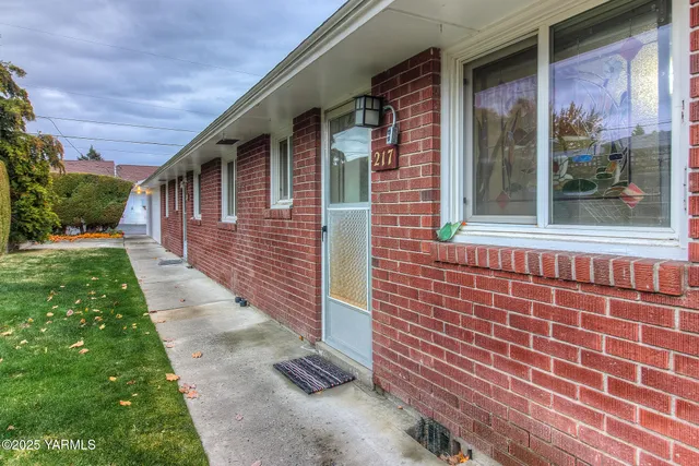 a view of a brick house with a yard