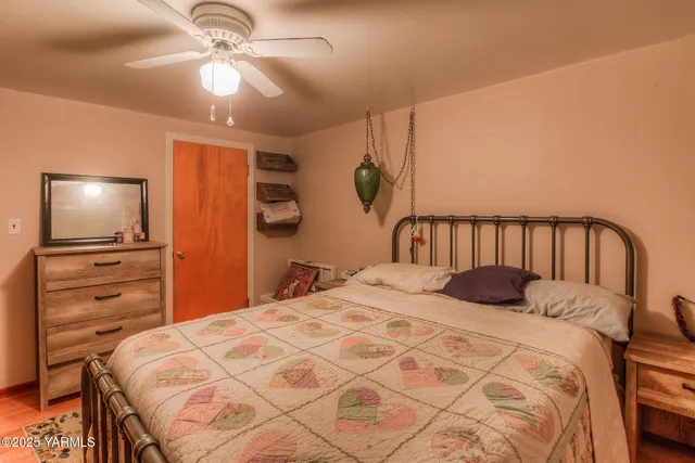 a bedroom with a bed and a flat tv screen on dresser