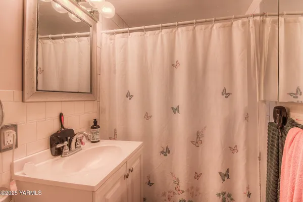 a bathroom with a sink a vanity and a shower curtain
